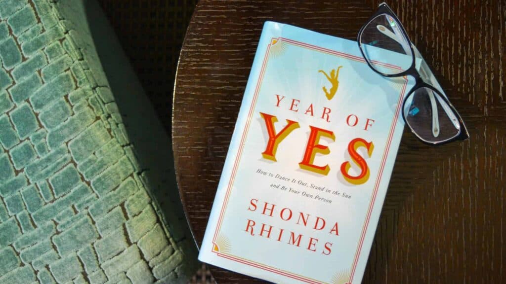 Year of Yes book on table with glasses.