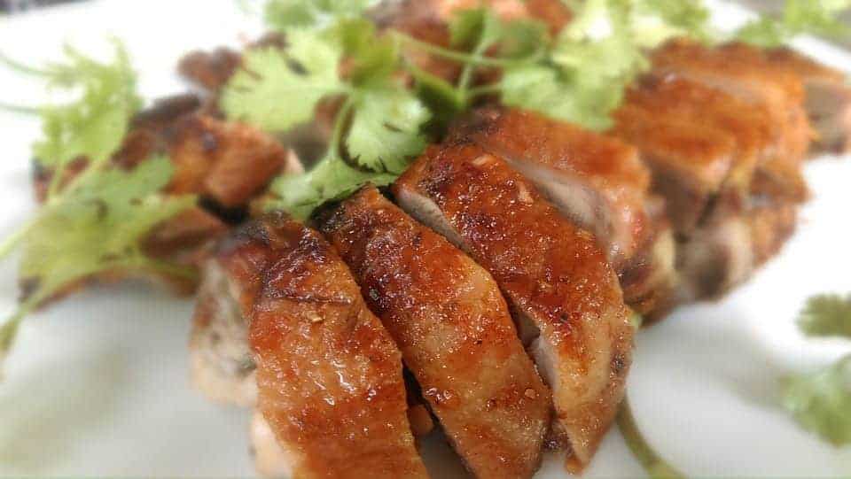 Cayenne roasted quail sliced on a plate.