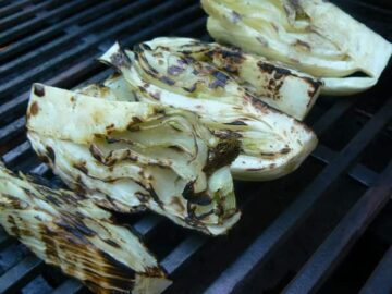 Grilled fennel on a grill grate.