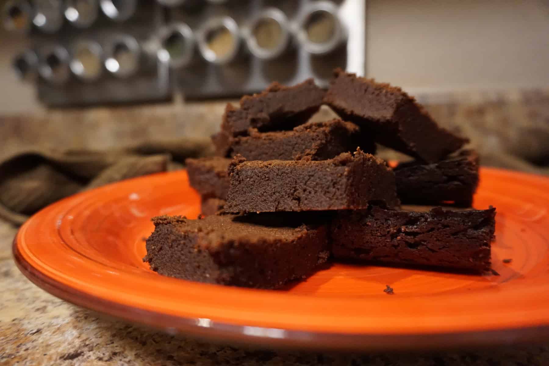 Ultimate fudge keto brownies stacked on a plate.