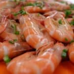 Shrimp on a plate garnished with chives.