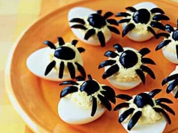 Spider deviled eggs on a plate