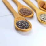 Seed Cycling: Spoons full of seeds on a countertop