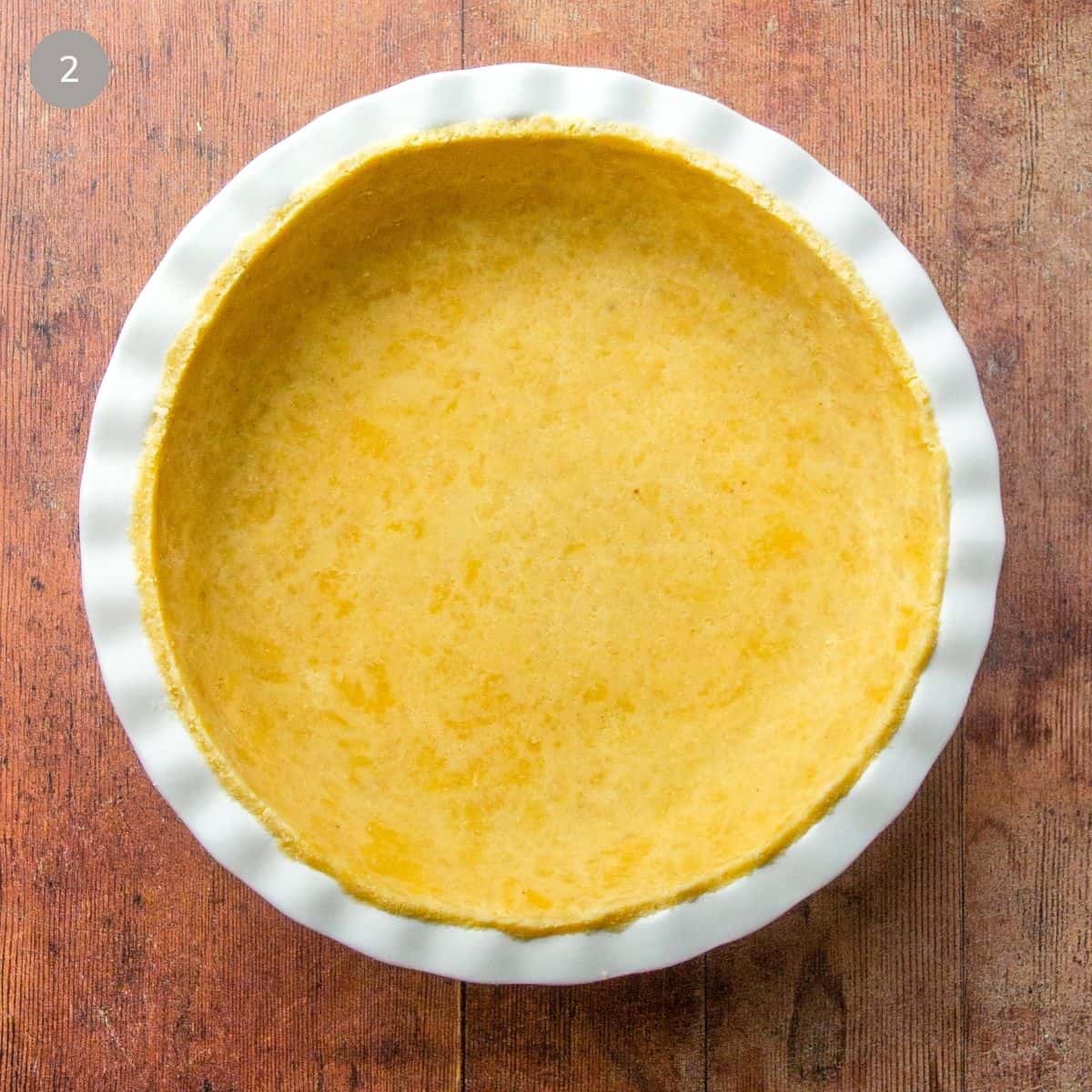 A pie crust placed in a white bowl, awaiting its filling for baking.