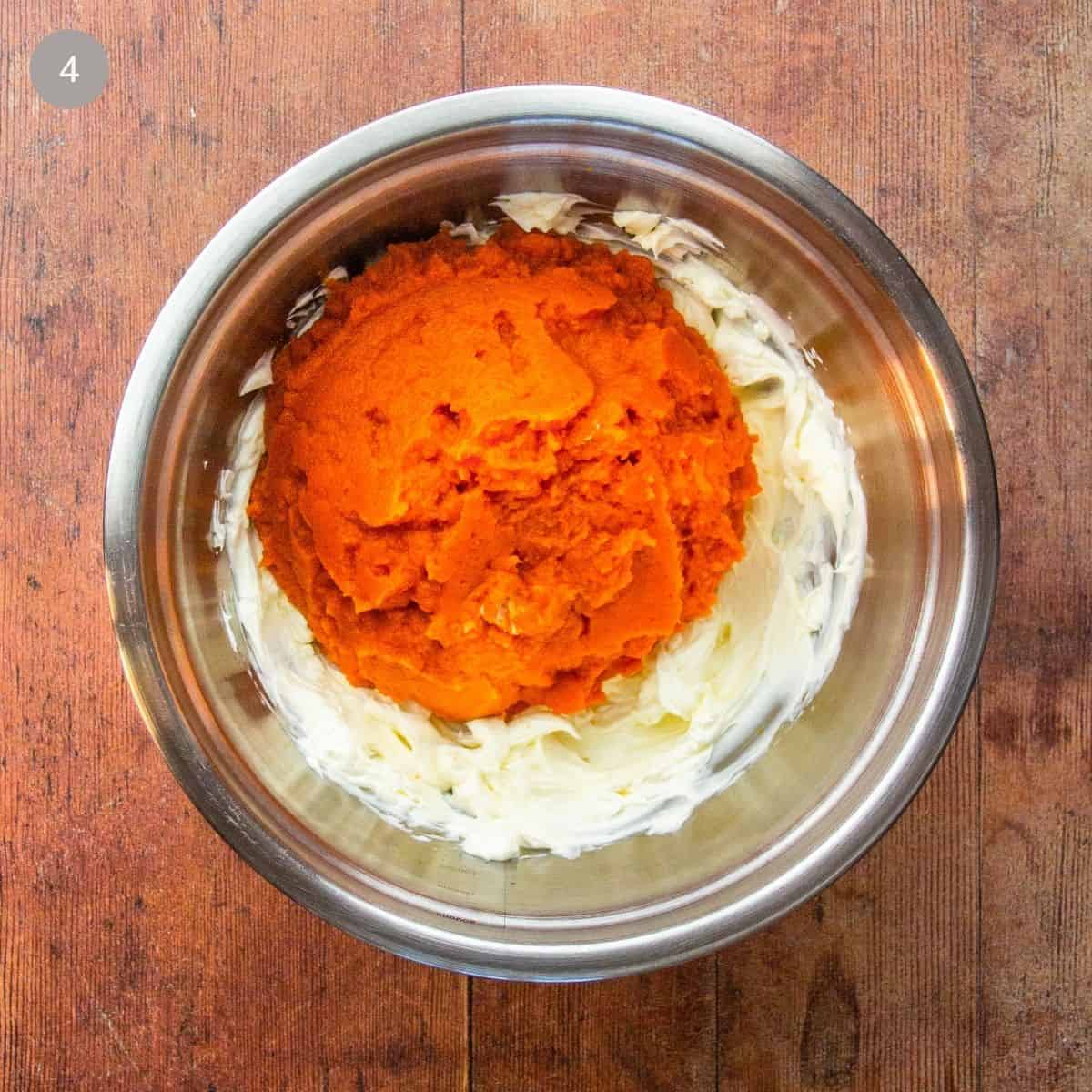 A bowl filled with pumpkin and cream cheese, prepared for mixing.