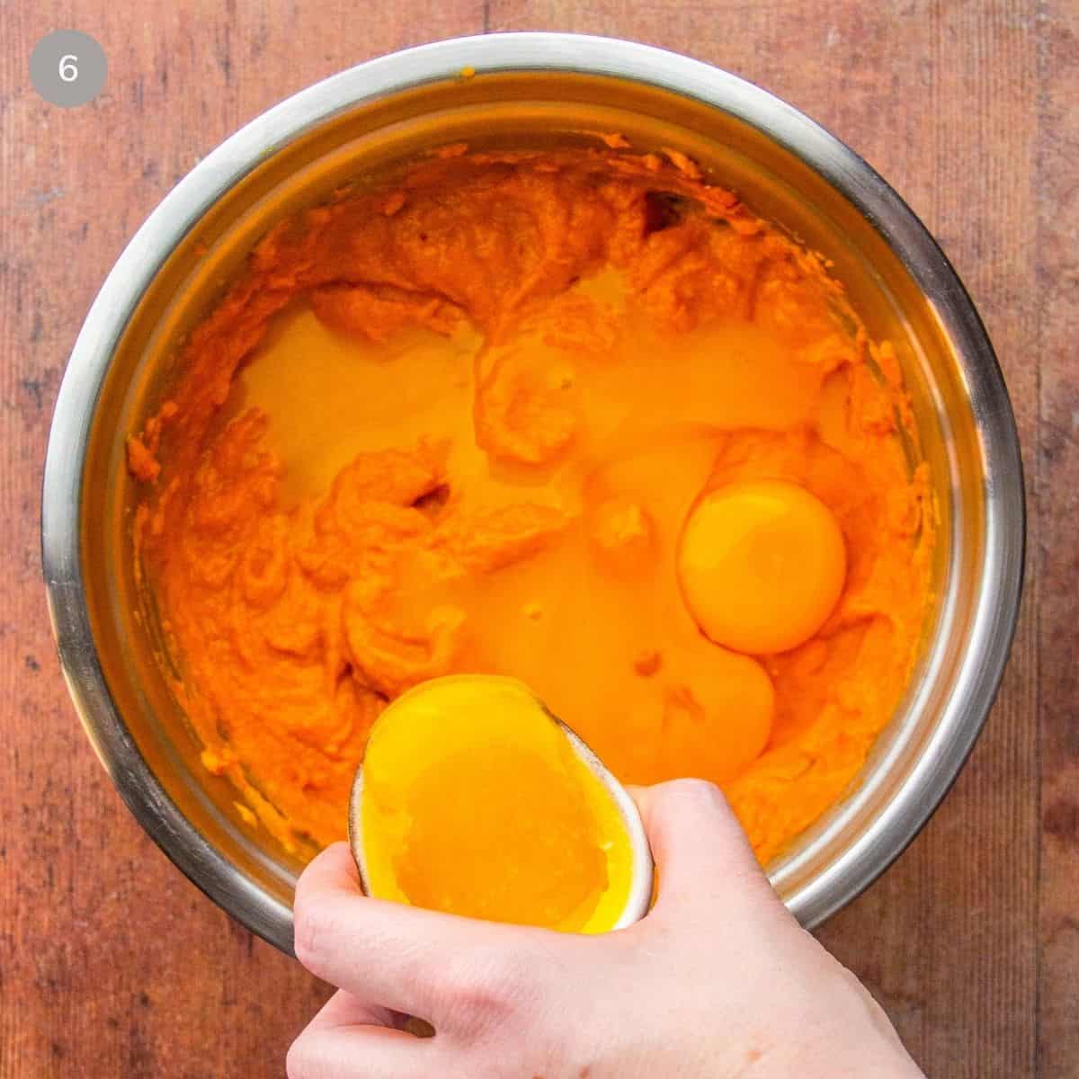 A person adding the eggs and beating until well combined.