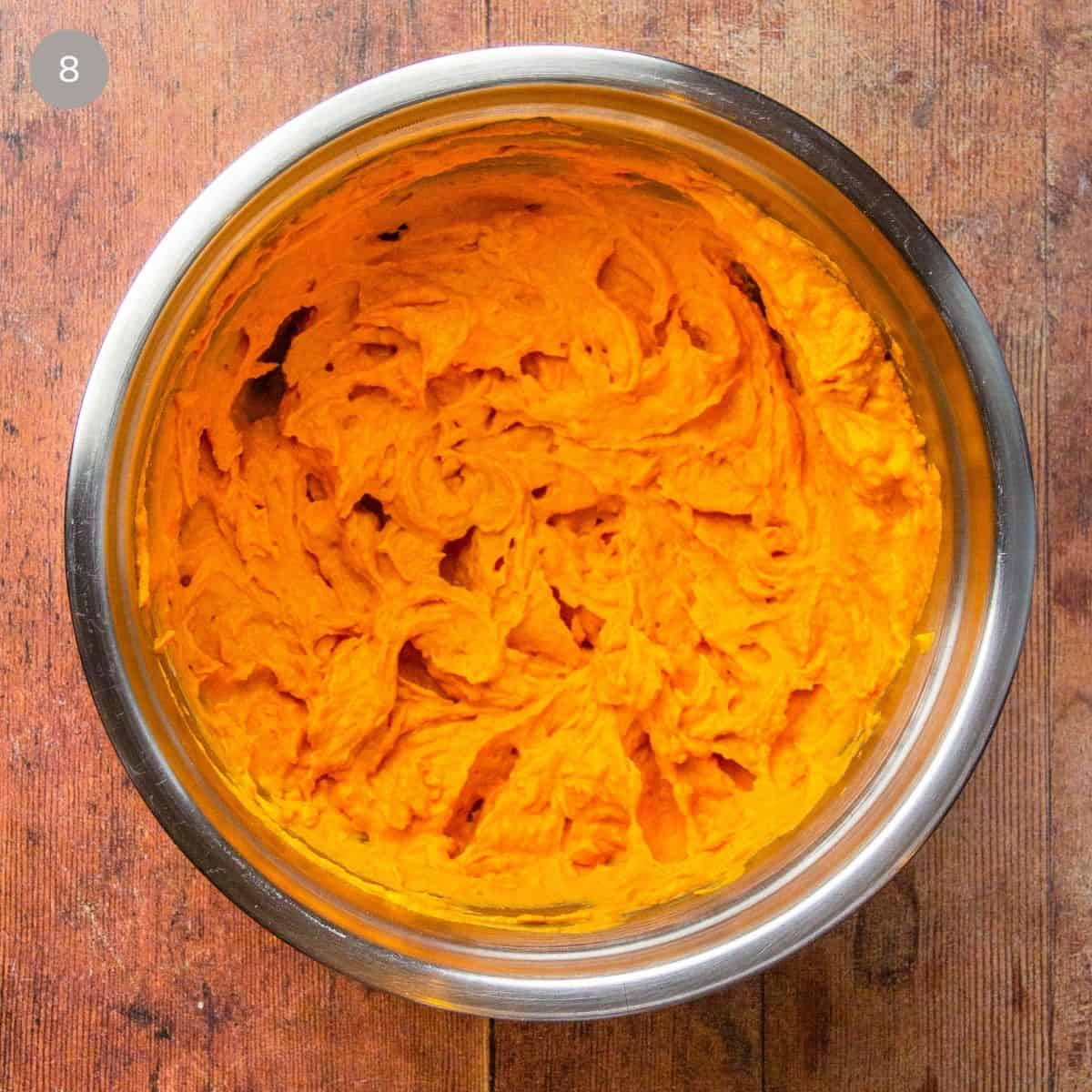 A bowl filled with pumpkin pie filling, ready to be poured into the pie crust for baking.