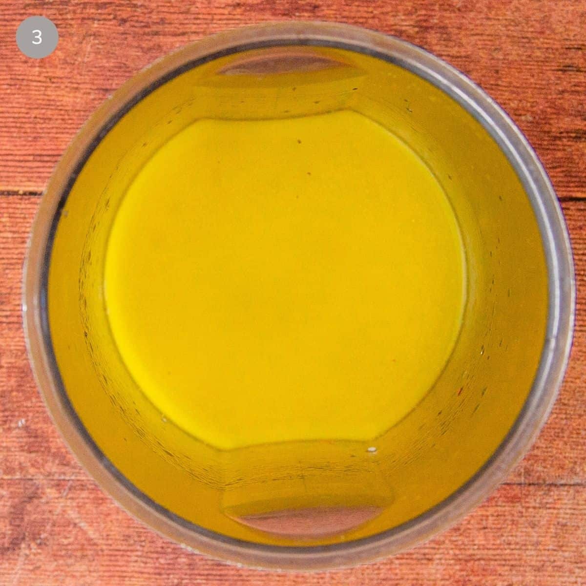 Blended lemon pepper vinaigrette, smooth and golden, in a small blender cup.