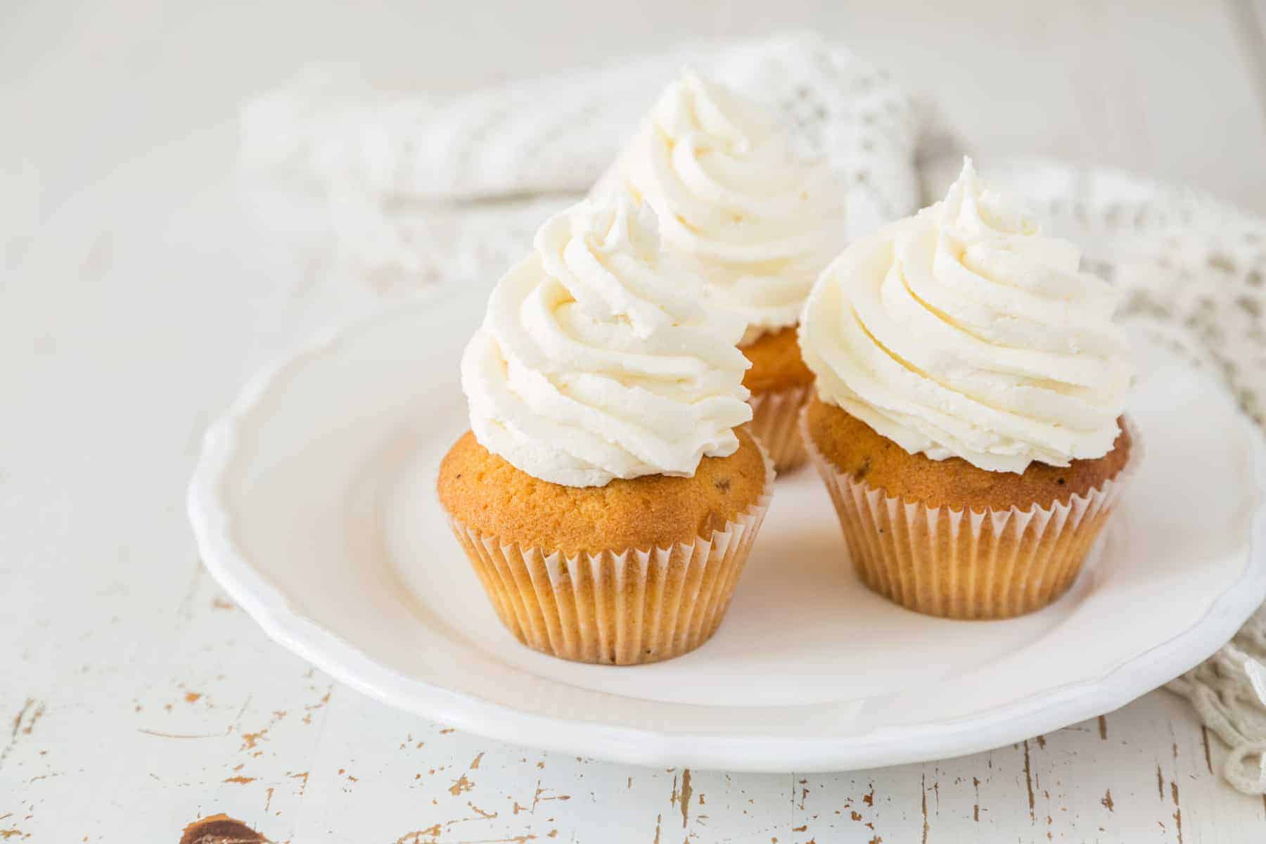 Vanilla cupcakes on white wood background