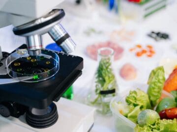 Microscope and veggies on lab table.
